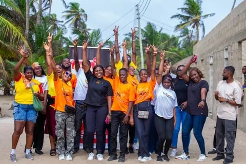 The MK Foundation volunteer team in orange shirts posing together