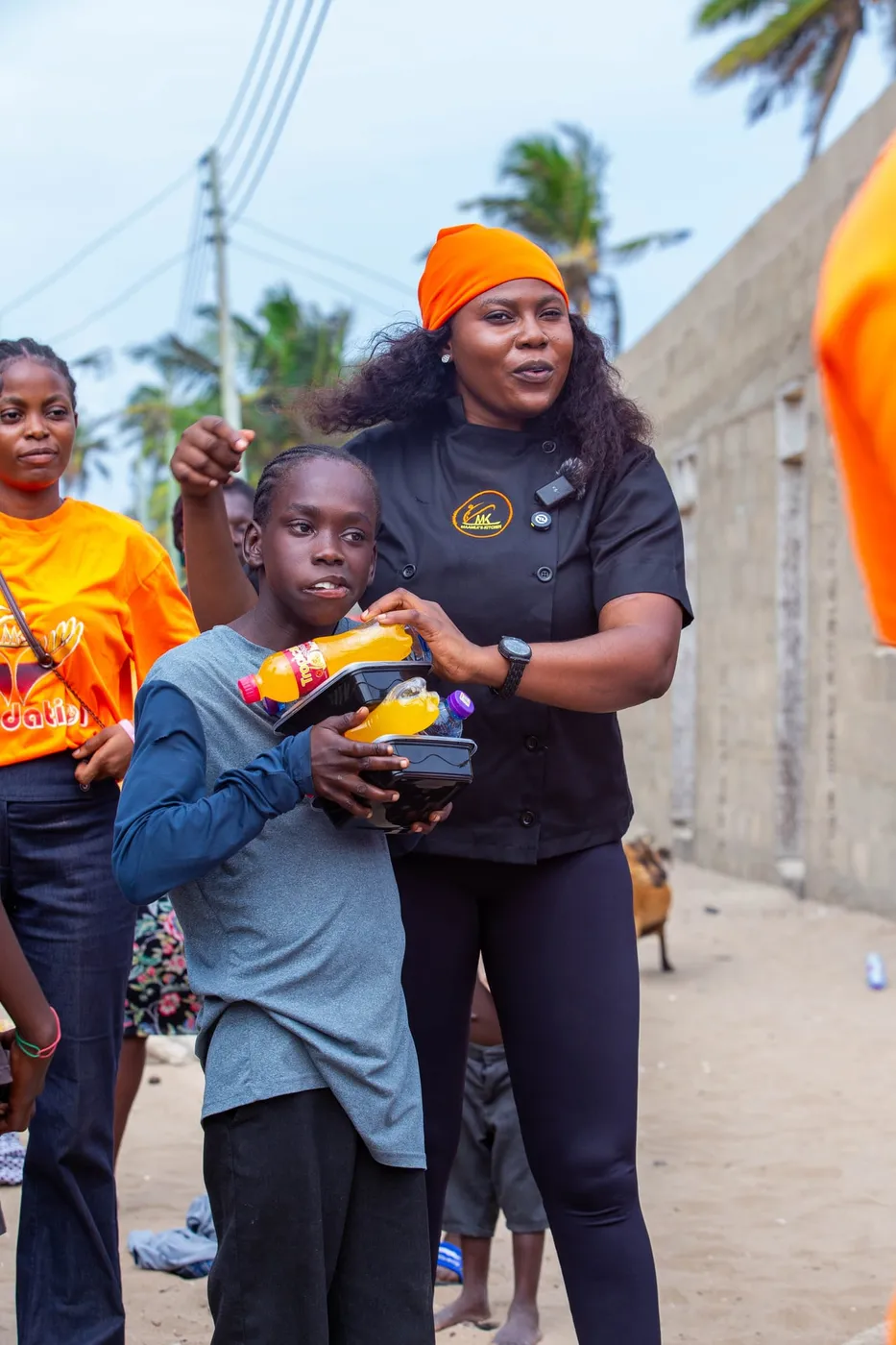 Chef Maamle handing a food pack to a child at an MK Foundation outreach