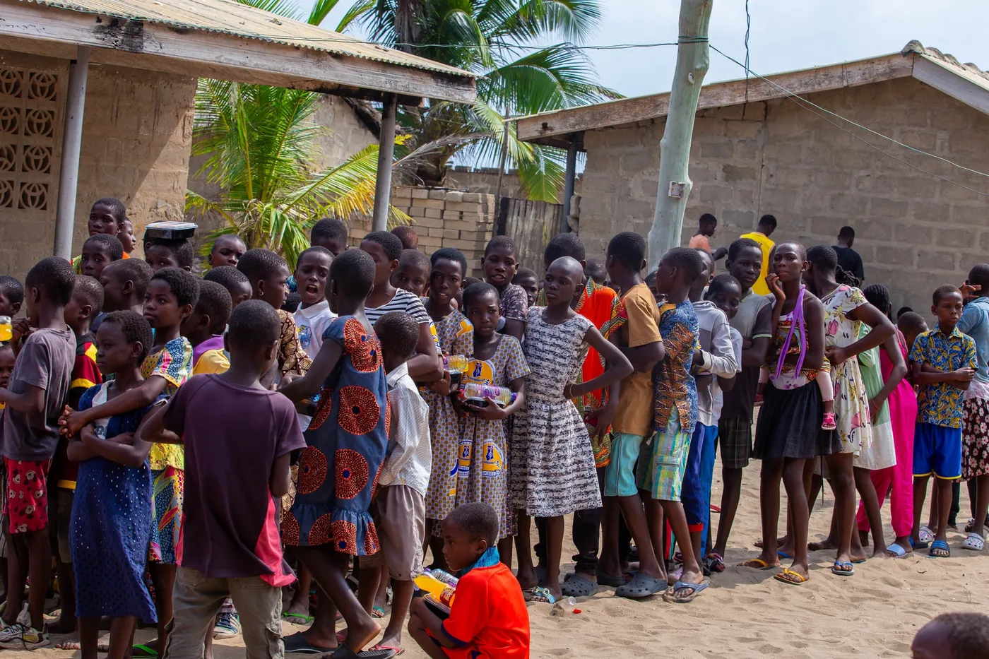 A large group of village children gathered for a food distribution